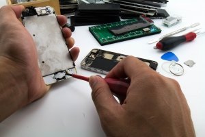 On the desk Repairman Preparing to change home button ฺButton of the mobile phone has been damaged.